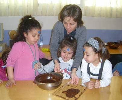 Hay que tener en cuenta las diversas formas de agrupamiento en función de los objetivos. En la imagen, una madre y tres alumnas participan en un taller de cocina. Fuente: CEIP Virgen de Navalazarza (Madrid)