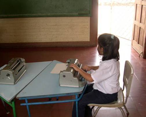 En ocasiones, los alumnos más vulnerables son «aparcados» en lugares específicos de los centros. En la imagen una niña con discapacidad visual aprende a escribir en Braille (Honduras).